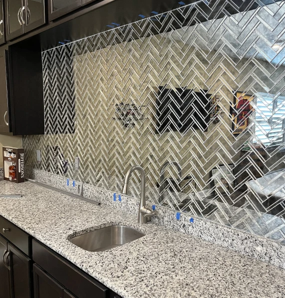 mirrored herringbone tile bar backsplash